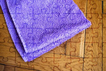 Colorful bent towel on wooden background: purple c jigsaw puzzle