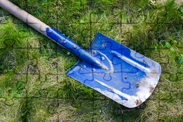 Blue shovel on a green grass jigsaw puzzle