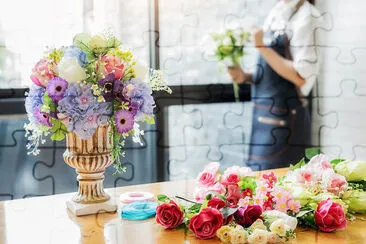 Woman hands making flower composition at florist w jigsaw puzzle